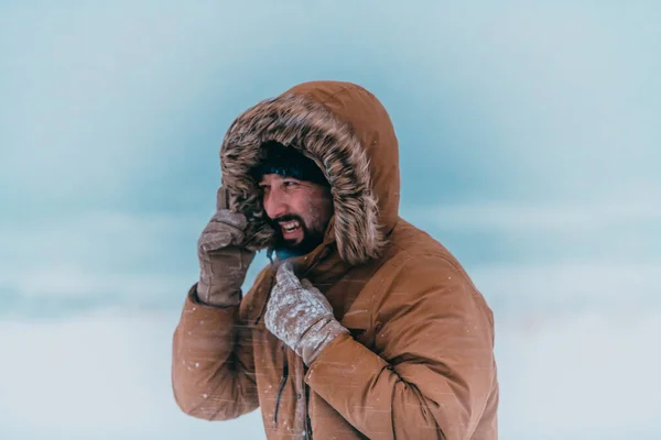 厚い茶色の冬のジャケットと手袋を着て寒い雪の領域で男の頭の写真 国の寒い地域での生活 — ストック写真