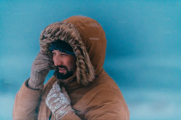 一个男人穿着厚厚的棕色冬季夹克和手套在寒冷的雪地里的头像照片 国家寒冷地区的生活 — 图库照片