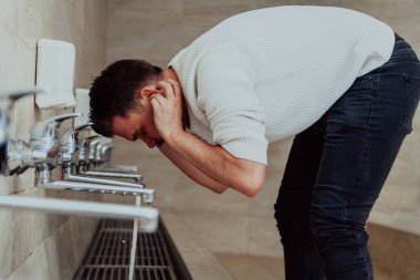 Bir müslüman abdest alıyor. Dua etmeden önce Müslümanların dini temizliği. Namazdan önce vücudu temizleme süreci. 