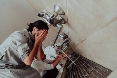 Bir müslüman abdest alıyor. Dua etmeden önce Müslümanların dini temizliği. Namazdan önce vücudu temizleme süreci. 