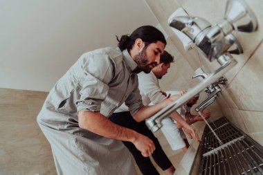 Bir müslüman abdest alıyor. Dua etmeden önce Müslümanların dini temizliği. Namazdan önce vücudu temizleme süreci. 