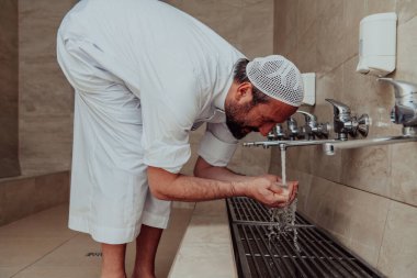 Bir müslüman abdest alıyor. Dua etmeden önce Müslümanların dini temizliği. Namazdan önce vücudu temizleme süreci. 