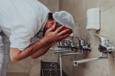 Bir müslüman abdest alıyor. Dua etmeden önce Müslümanların dini temizliği. Namazdan önce vücudu temizleme süreci. 