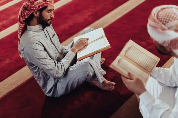 ラマダーン月のムスリムの祝日に現代のモスクでクルアーンの聖書を読むムスリムのグループ — ストック写真