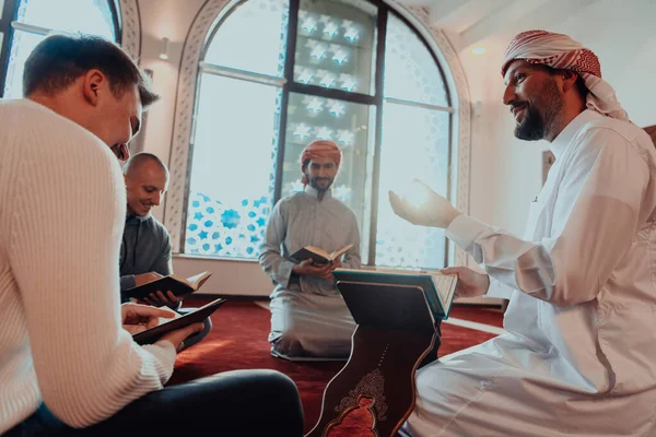 在穆斯林斋月期间 一群穆斯林在一座现代清真寺里读 古兰经 — 图库照片