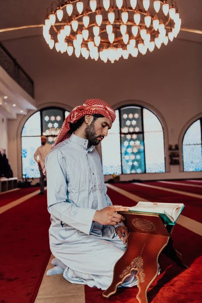在穆斯林神圣的拉那赞月 一位穆斯林在一座现代化的大清真寺里读到了神圣的伊斯兰书籍 古兰经 — 图库照片