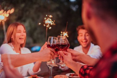 Bir grup mutlu arkadaş tatil tatillerini fıskiyelerle kutlarken ve kırmızı şarap içerken aynı zamanda güzel bir yaz akşamı nehir kenarında piknik yapıyorlar.. 