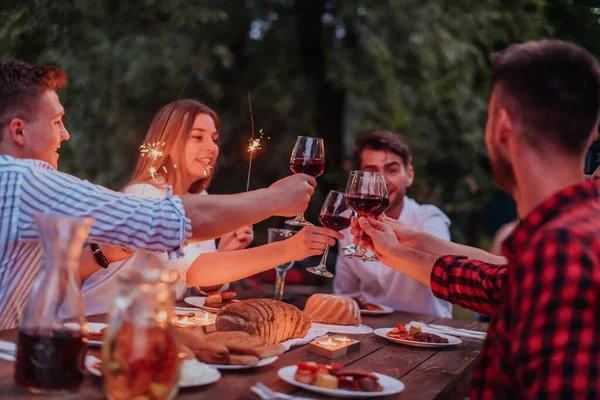 Bir grup mutlu arkadaş tatil tatillerini fıskiyelerle kutlarken ve kırmızı şarap içerken aynı zamanda güzel bir yaz akşamı nehir kenarında piknik yapıyorlar.. 