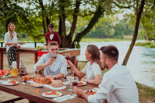 Bir grup mutlu arkadaş yaz tatili boyunca dışarıda piknik yapıyorlar. Nehir kenarında güzel bir doğada.. 
