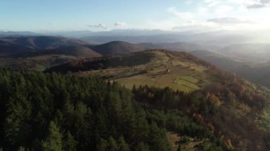 Cinematic Aerial flight over the hill with forest and tree tops with a beautiful sunset in the background. High quality 4k footage