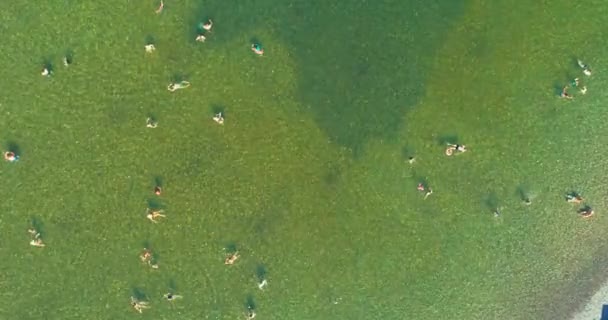 在旅游旺季 空中无人飞机俯瞰拥挤的城市湖泊 成群的人在海里游泳 度假时穿着泳衣在海里洗澡的人很多 — 图库视频影像
