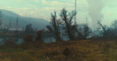 Abstract aerial view of coal power plant high pipes with black smoke moving up polluting atmosphere at sunny day. High quality 4k footage