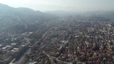 Saraybosna ve ulusal kütüphanenin hava görüntüleri, gün batımında Saraybosna kenti manzaralı Vijecnica kütüphanesinin üzerinde uçuyor. Yüksek kalite 4k görüntü