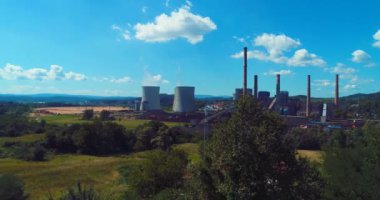 Aerial view of coal power plant high pipes with black smoke moving up polluting atmosphere at sunny day. High quality 4k footage