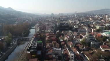 Saraybosna ve ulusal kütüphanenin hava görüntüleri, gün batımında Saraybosna kenti manzaralı Vijecnica kütüphanesinin üzerinde uçuyor. Yüksek kalite 4k görüntü