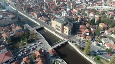 Saraybosna ve ulusal kütüphanenin hava görüntüleri, gün batımında Saraybosna kenti manzaralı Vijecnica kütüphanesinin üzerinde uçuyor. Yüksek kalite 4k görüntü