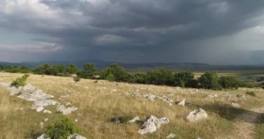Nature landscape meadow aerial view. In the background, cloudy sky. You can see how it rains from the cloud. High quality 4k footage