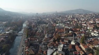 Saraybosna ve ulusal kütüphanenin hava görüntüleri, gün batımında Saraybosna kenti manzaralı Vijecnica kütüphanesinin üzerinde uçuyor. Yüksek kalite 4k görüntü