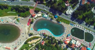 Aerial drone view of overcrowded urban lake during peak of tourist season. Crowd of people swimming in the sea at summer. Large group of people in swimsuit bathing in ocean during vacation. High