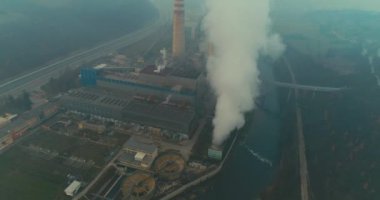 Abstract aerial view of coal power plant high pipes with black smoke moving up polluting atmosphere at sunny day. High quality 4k footage