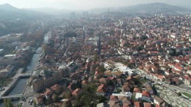 Saraybosna ve ulusal kütüphanenin hava görüntüleri, gün batımında Saraybosna kenti manzaralı Vijecnica kütüphanesinin üzerinde uçuyor. Yüksek kalite 4k görüntü