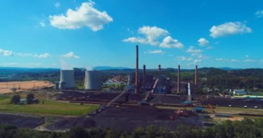Aerial view of coal power plant high pipes with black smoke moving up polluting atmosphere at sunny day. High quality 4k footage