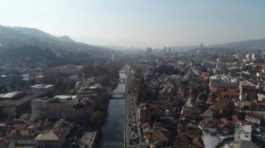 Saraybosna ve ulusal kütüphanenin hava görüntüleri, gün batımında Saraybosna kenti manzaralı Vijecnica kütüphanesinin üzerinde uçuyor. Yüksek kalite 4k görüntü