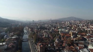 Saraybosna ve ulusal kütüphanenin hava görüntüleri, gün batımında Saraybosna kenti manzaralı Vijecnica kütüphanesinin üzerinde uçuyor. Yüksek kalite 4k görüntü