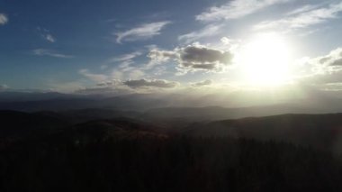 Cinematic Aerial flight over the hill with forest and tree tops with a beautiful sunset in the background. High quality 4k footage