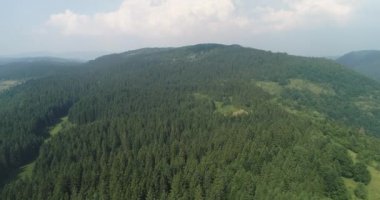 Aerial Cinematic clip: Drone flying over a beautiful summer landscape of endless meadows and hills. Top view to the farm wheatfield. High quality 4k footage
