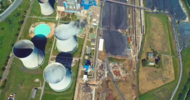 Aerial view of coal power plant high pipes with black smoke moving up polluting atmosphere at sunny day. High quality 4k footage