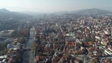 Saraybosna ve ulusal kütüphanenin hava görüntüleri, gün batımında Saraybosna kenti manzaralı Vijecnica kütüphanesinin üzerinde uçuyor. Yüksek kalite 4k görüntü