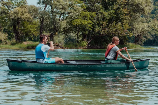 一对冒险家朋友正在一条被美丽的大自然环绕的野河中划船 — 图库照片