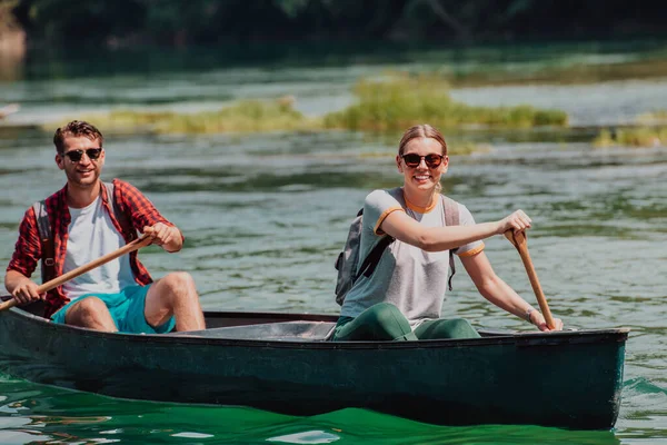 カップル冒険的な探検家の友人は美しい自然に囲まれた野生の川でカヌーです — ストック写真