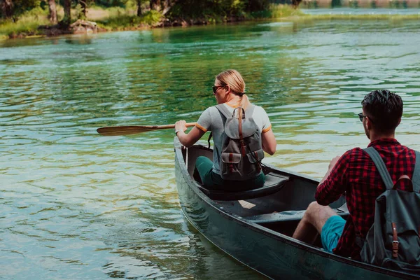 一对冒险家朋友正在一条被美丽的大自然环绕的野河中划船 — 图库照片