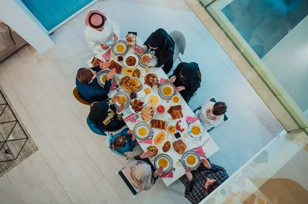 Top view of Muslim family having Iftar dinner drinking water to break feast. Eating traditional food during Ramadan feasting month at home. The Islamic Halal Eating and Drinking in modern home.