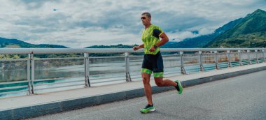 An athlete running a marathon and preparing for his competition. Photo of a marathon runner running in an urban environment. 