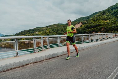 An athlete running a marathon and preparing for his competition. Photo of a marathon runner running in an urban environment. 