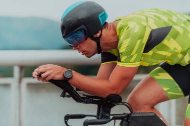Active triathlete in sportswear and with a protective helmet riding a bicycle. Selective focus .