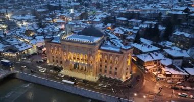 Sarajevo city hall or national library in town center aerialhyper lapse or time lapse. Landmark in capital of Bosnia and Herzegovina covered with fresh snow in the winter season at night. Hi quality