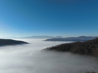 Aerial View. Flying over the high mountains in beautiful clouds. Aerial Drone camera shot. Air pollution clouds over Sarajevo in Bosnia and Herzegovina. Hi quality 4K footage. 