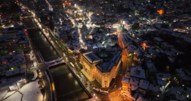 Sarajevo city hall or national library in town center aerialhyper lapse or time lapse. Landmark in capital of Bosnia and Herzegovina covered with fresh snow in the winter season at night. Hi quality