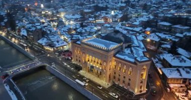 Sarajevo city hall or national library in town center aerialhyper lapse or time lapse. Landmark in capital of Bosnia and Herzegovina covered with fresh snow in the winter season at night. Hi quality