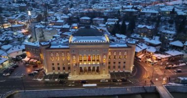 Sarajevo city hall or national library in town center aerialhyper lapse or time lapse. Landmark in capital of Bosnia and Herzegovina covered with fresh snow in the winter season at night. Hi quality