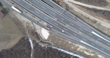 Aerial view of mountain twisted road in the winter. Epic, snowy white winter in the mountains. High rocky mountains and clean road through frozen forest. High quality 4k footage