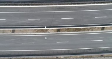 Aerial view of mountain twisted road in the winter. Epic, snowy white winter in the mountains. High rocky mountains and clean road through frozen forest. High quality 4k footage