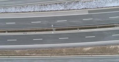 Aerial view of mountain twisted road in the winter. Epic, snowy white winter in the mountains. High rocky mountains and clean road through frozen forest. High quality 4k footage