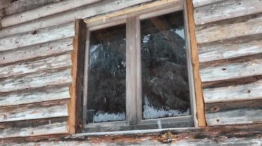Splendid mountain winter landscape with secluded small wooden alpine cottage among the fir trees fully covered by snow during snow fall. Hi quality 4K slow motion footage. 