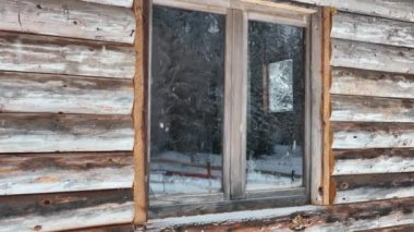 Splendid mountain winter landscape with secluded small wooden alpine cottage among the fir trees fully covered by snow during snow fall. Hi quality 4K slow motion footage. 