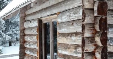 Splendid mountain winter landscape with secluded small wooden alpine cottage among the fir trees fully covered by snow during snow fall. Hi quality 4K slow motion footage. 